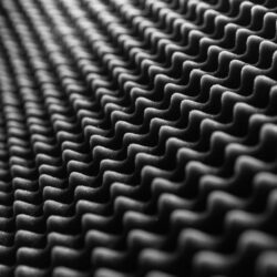 Close-up view of textured soundproof foam in black and white, showcasing its detailed pattern.